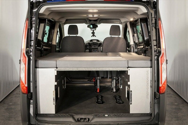 Kit cama básico de Furgomania montado en una Ford Transit Custom, visto desde el portón trasero abierto